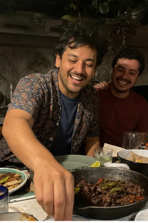 Mateo laughing at dinner with friends