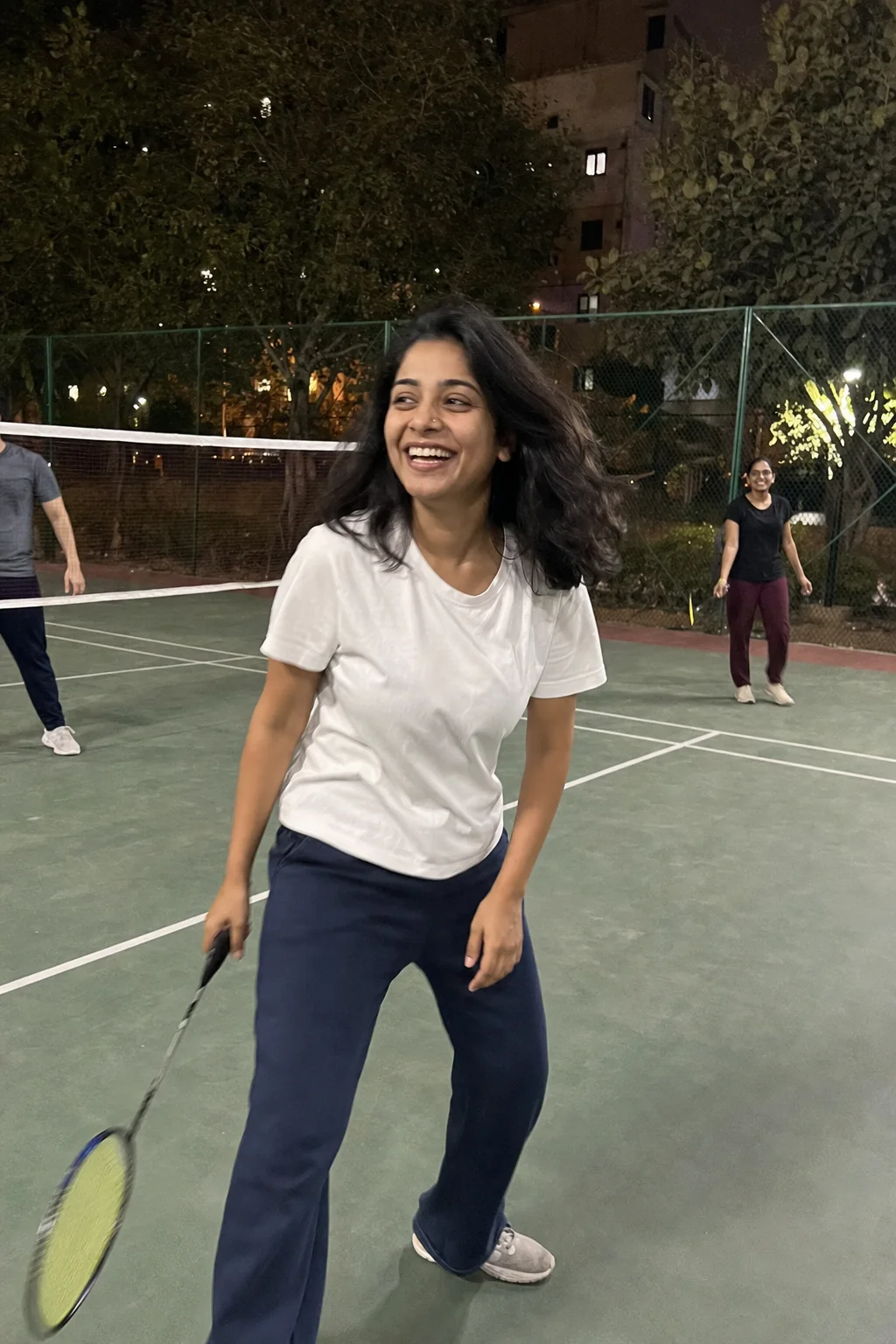 Meera laughing during badminton with friends after work